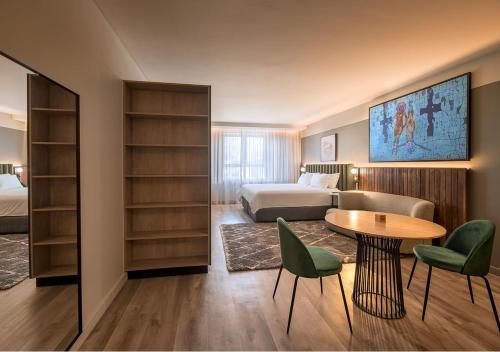 um quarto de hotel com uma cama, uma mesa e cadeiras em The Rockefeller Hotel by NEWMARK na Cidade do Cabo