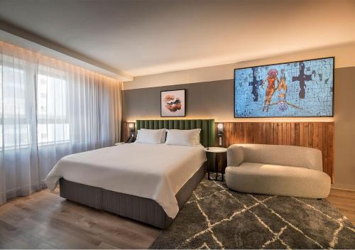 a bedroom with a large bed and a chair at The Rockefeller Hotel by NEWMARK in Cape Town