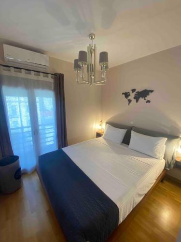 een slaapkamer met een groot bed en een kroonluchter bij 365 Urban Suite in Heraklion