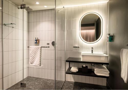a bathroom with a shower and a sink and a mirror at The Rockefeller Hotel by NEWMARK in Cape Town