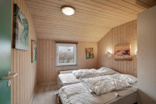 1 dormitorio con 1 cama en una habitación con paredes de madera en Vandstedet 14, 6430 Nordborg en Nordborg