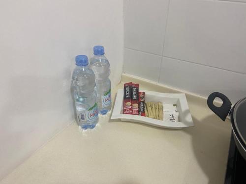 Un par de botellas de agua y un paquete de cigarrillos. en Nice Studio Unit at Tiara Imperio Bangi en Kajang