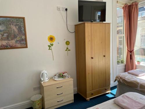 ein Schlafzimmer mit einer Kommode mit einem TV darüber in der Unterkunft The Blue Moon in Blackpool