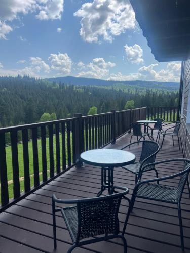 four tables and chairs on a deck with a view at Мелодія Гір Вид на гори in Vorokhta