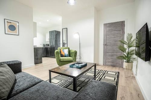 a living room with a couch and a table at Ground Floor 2 Bedroom Apartment - Bayard Apartments in Peterborough