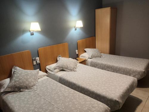 Habitación de hotel con 2 camas y 2 lámparas en Hostal Can Jaume, en Mollerusa