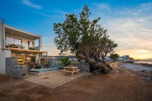a house with a tree in front of it at Milatos Seaside Suites in Milatos