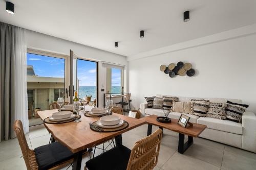 a living room with a table and chairs and a couch at Milatos Seaside Suites in Milatos