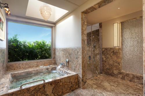 La salle de bains est pourvue d'une grande baignoire et d'une fenêtre. dans l'établissement Mementos by ITC Hotels, Ekaaya, Udaipur, à Udaipur
