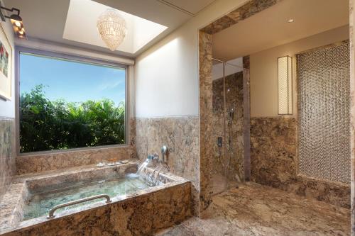 a bathroom with a large tub and a window at Mementos by ITC Hotels, Ekaaya, Udaipur in Udaipur