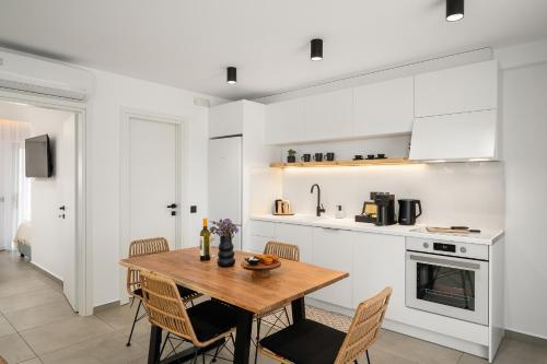 uma cozinha e sala de jantar com uma mesa de madeira e cadeiras em Milatos Seaside Suites em Milatos