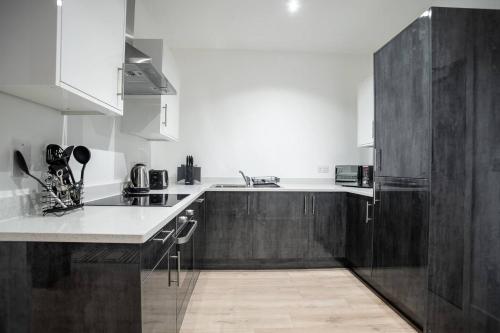 a kitchen with wooden cabinets and a white counter top at Ground Floor 2 Bedroom Apartment - Bayard Apartments in Peterborough