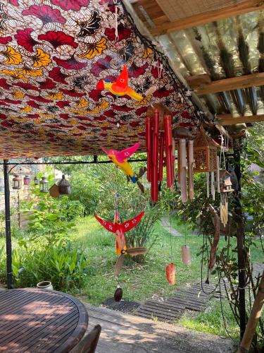 a group of colorful kites hanging from a roof at La Chambre Du Voyageur in Soustons