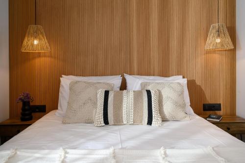 a bed with white sheets and pillows in a bedroom at Milatos Seaside Suites in Milatos