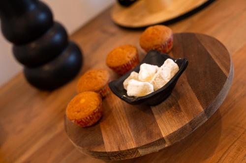 a bowl of butter and orange muffins on a wooden table at Milatos Seaside Suites in Milatos