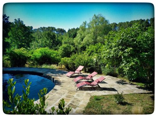 a group of pink chairs sitting next to a pool at Hortense Grange 2/4 personnes in Sanilhac