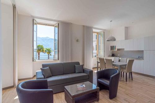 un soggiorno con divano e tavolo di Maioliche Apartments Griante a Griante Cadenabbia