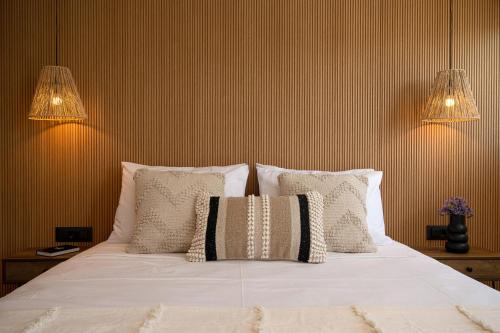a bed with white sheets and pillows in a room at Milatos Seaside Suites in Milatos