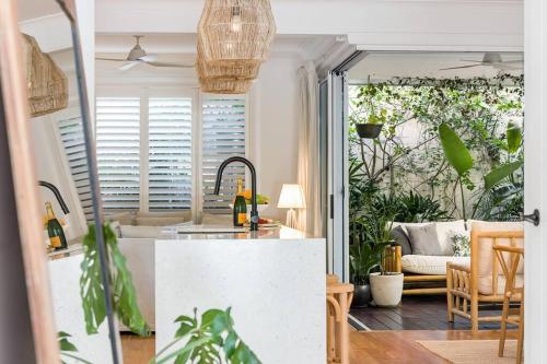 cocina y sala de estar con sofá y mesa en Villa Wallah Luxury in Byron Bay, en Byron Bay
