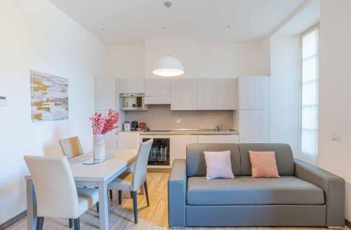 a living room with a couch and a table with chairs at Maioliche Apartments Griante in Griante Cadenabbia