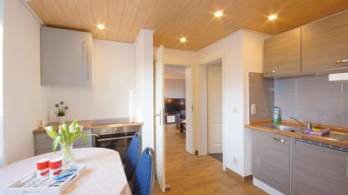 eine Küche mit einem Tisch und blauen Stühlen in einem Zimmer in der Unterkunft Ferienwohnung Bruchalla in Parchtitz