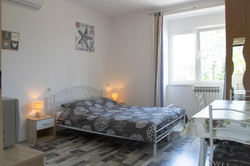 1 dormitorio con cama y ventana en Apartments Teo en Opatija