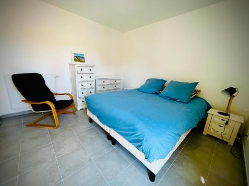 - une chambre avec un lit bleu et une chaise dans l'établissement Chez Caro, à Port-Vendres