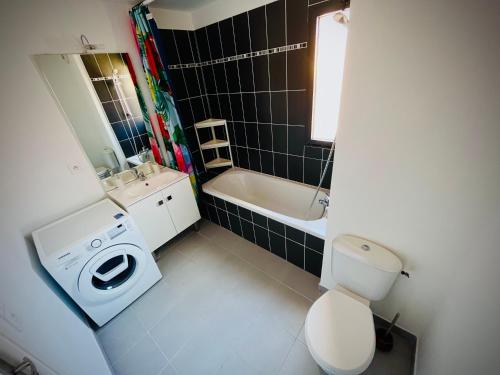 une salle de bain avec toilettes et lavabo et une machine à laver dans l'établissement Chez Caro, à Port-Vendres