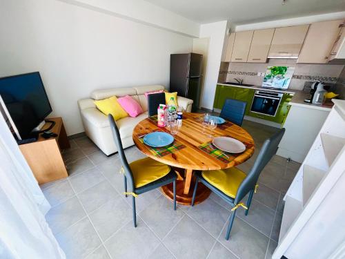 une cuisine et une salle à manger avec une table et des chaises en bois dans l'établissement Chez Caro, à Port-Vendres