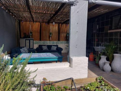 a patio with a blue couch and a table at Hide Away on 21 in Mossel Bay