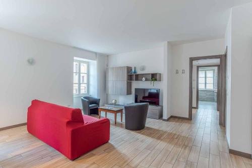 a living room with a red couch and a table at Maioliche Apartments Griante in Griante Cadenabbia