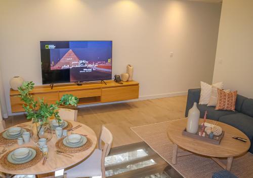 a living room with a table and a tv at Lagoona Beach Luxury Resort and Spa in Manama