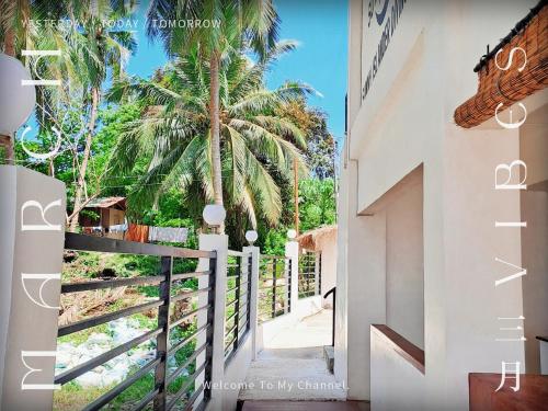 een trap naar een huis met een palmboom bij sunny islander diving resort in Looc