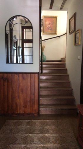a hallway with a staircase with a mirror and a door at Casa Rural con encanto Señorio Manchego ALBACETE in Yeste