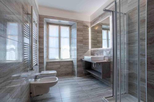 a bathroom with two toilets and a sink and a shower at Maioliche Apartments Griante in Griante Cadenabbia
