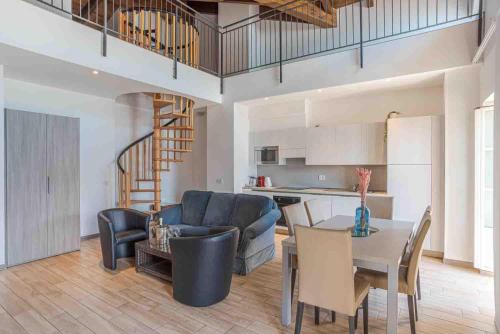 a kitchen and living room with a table and chairs at Maioliche Apartments Griante in Griante Cadenabbia