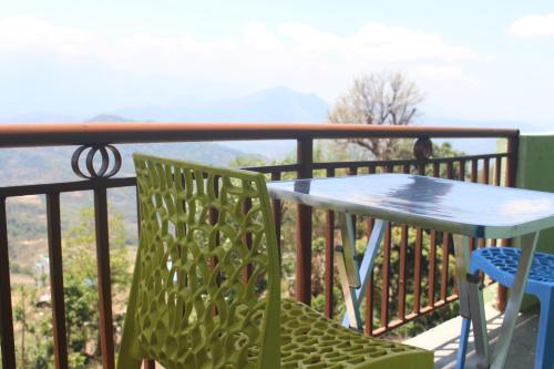 a table and chairs on a balcony with a view at Universal Hotel & Lodge - Gorkha in Gorkhā