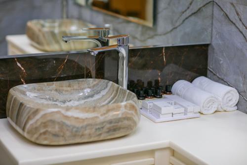 a bathroom sink with a stone sink at Nohur Hotel Gabala in Gabala