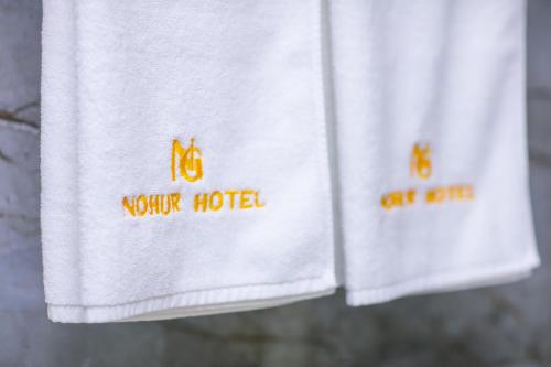 two white towels with the words mother hotel on them at Nohur Hotel Gabala in Gabala