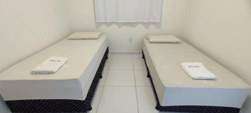 two beds in a small room with white walls at Ap da Thay - Arretado in Campina Grande
