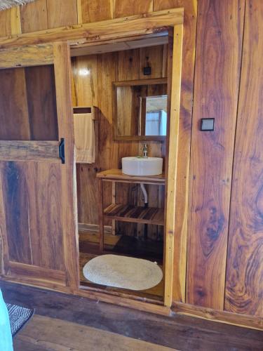 a bathroom with a sink in a wooden wall at CASE de ROBINSON in Lomé