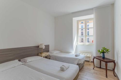 a hotel room with two beds and a window at Maioliche Apartments Griante in Griante Cadenabbia