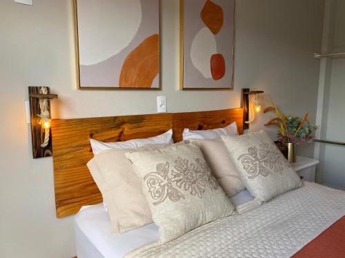 um quarto com uma cama branca e uma cabeceira em madeira em Hotel APART Zuccolotto 201 em Aracruz