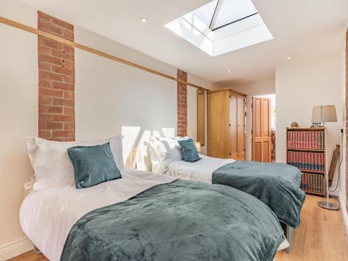 two beds in a bedroom with a skylight at Cyrabel in Boultham