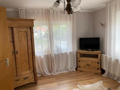uma sala de estar com televisão e janela em Haus Vaquero - Rancho el Rosal em Bad Mergentheim