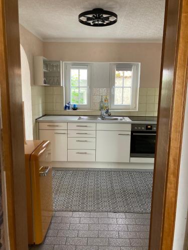 a kitchen with white cabinets and a sink at Haus Vaquero - Rancho el Rosal in Bad Mergentheim