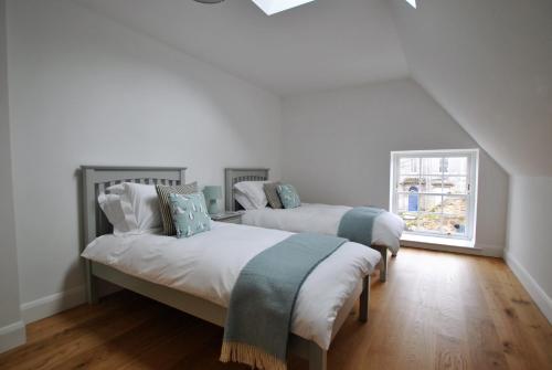 Duas camas num quarto branco com uma janela em Walters Neuk Anstruther- luxury coastal home em Anstruther