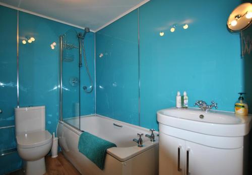 a bathroom with a tub and a toilet and a sink at Watersedge Apartment- cosy home by the sea in Anstruther