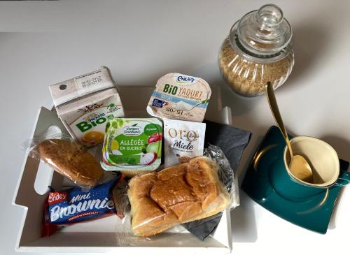 a lunch box with a sandwich and bread and a cup of coffee at AUX 4 LOGIS Appart-hotel - Studio Le Flore - Petit déjeuner inclus 1ère nuit in Foix