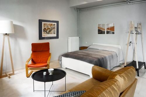 um quarto com uma cama, um sofá e uma cadeira em Studio 70 em Árgos